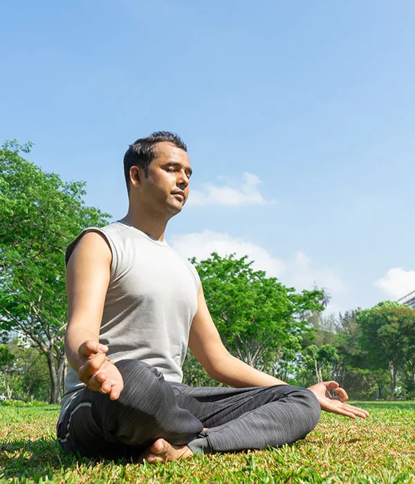 Mann beim Yoga im Park zur Erdung des Körpers
