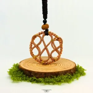 Handgefertigter Triple Infinity Tensor-Ring aus Kupfer zur Erdung und energetischen Heilung, dargestellt auf natürlicher Holzscheibe